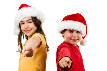 Christmas time - girl and boy with Santa Claus Hat pointing 
