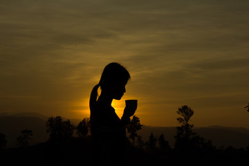Fototapeta na wymiar Woman drinking cup of hot tea or coffee outdoors in sunlight