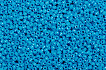 Multicolored blue glass seed beads background.