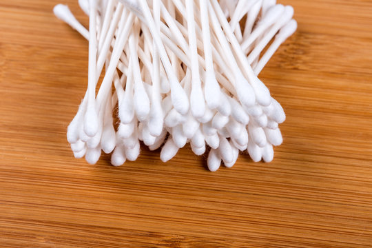 Pile of white cotton swabs isolated on wood background