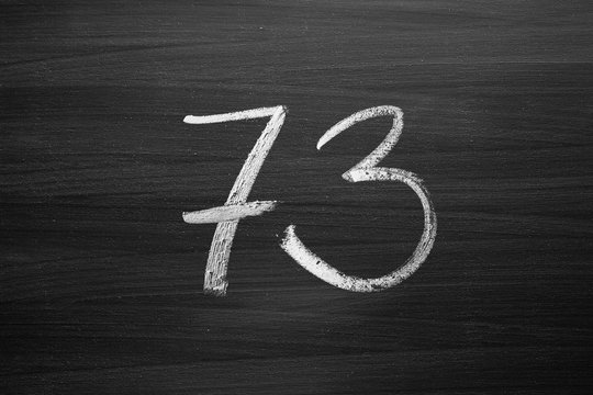 number seventy three enumeration written with a chalk on the blackboard