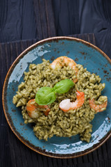 Spinach and shrimps risotto, black wooden surface, above view