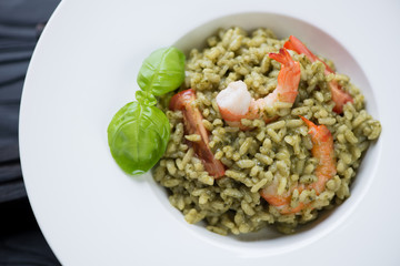 Close-up of risotto with spinach, tiger shrimps and tomatoes