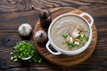 Bowl with porcini cream-soup in a rustic wooden setting