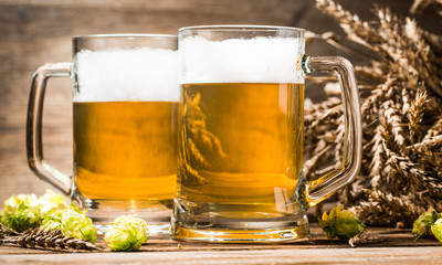 Two beer mugs close-up on wooden table