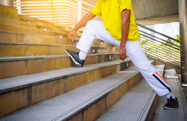 Sportsman stretching at stairs before or after exercise