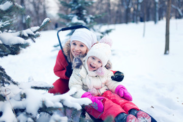 Fototapeta na wymiar Happy mother and baby playing outdoors in winter