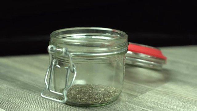 Superfood in a jar - Putting a few teaspoons of chia seeds in a glass jar 