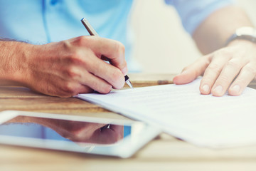 Close-up of men signing document, contract