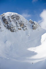 Snow covered rocky mountain with blue sky, landscape