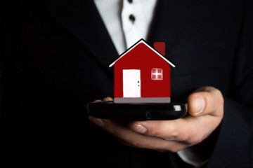man holding phone and house