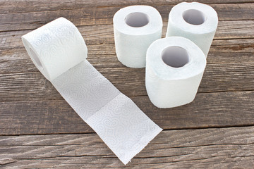 Toilet paper rolls on wood background