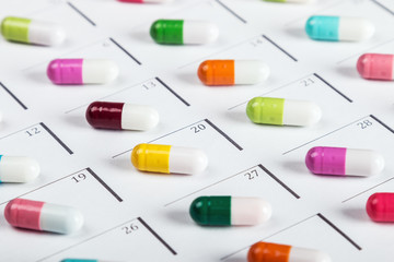 pills are of different color on the calendar. Schedule medication. Focus on a light green pill