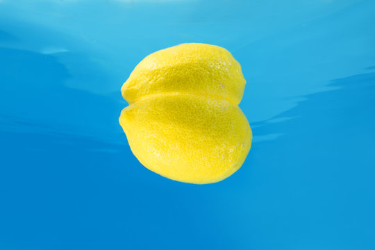 Lemon splashing in water on blue background