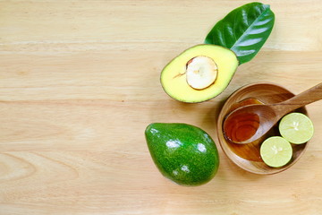 Fresh avocado fruits on a wood background.