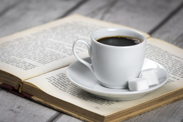Cup of Coffee and Book/ White Cup of Coffee and vintage book on white wooden table