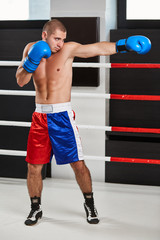 Boxer in blue gloves warming up in the ring