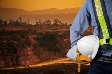 Engineer holding white helmet with coal mining
