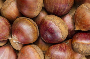 A background with lots of fresh raw chestnuts.