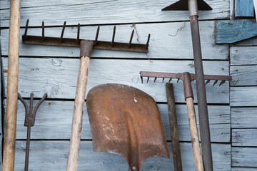 The old rusty tradition tools, instruments, implements and farm or household equipment on wooden...