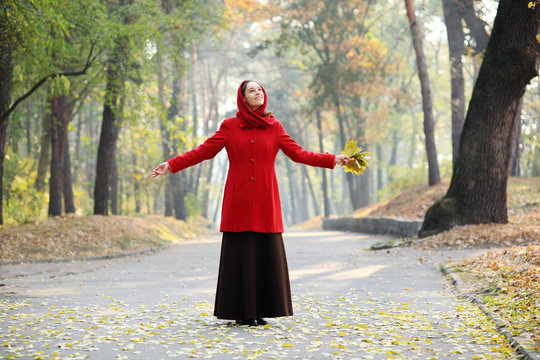 Beautiful young girl walking in autumn park.