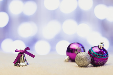 Happy new year / Marry Christmas New Year's toys for Christmas tree. Silver and purple balls and bell with purple bow on white background and bokeh