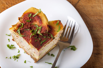 Portion of layered moussaka with parsley on plate