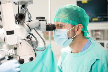 Surgeon looking through a microscope
