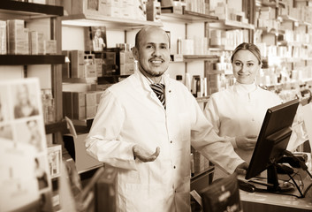 pharmacists standing with a cash desk