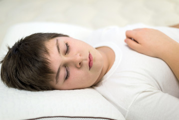 Boy teenager sleeping on anatomic pillow