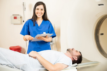 Obraz premium Beautiful nurse next to a CT scanner