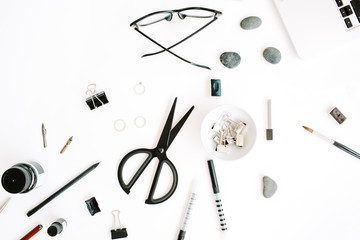 Flat lay, top view office table desk. Workspace with laptop, scissors, glasses, pen on white background.