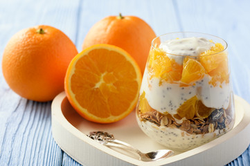 Yogurt dessert with muesli, chia seeds and oranges.