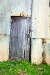 Old rusty zinc sheet wall with old wooden door