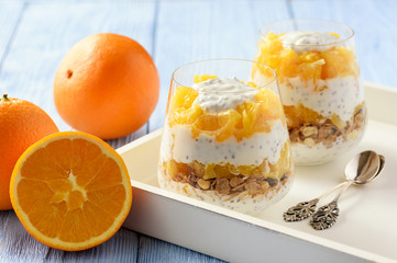 Yogurt dessert with muesli, chia seeds and oranges.