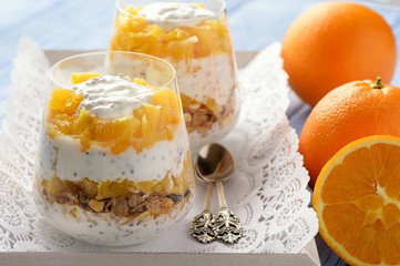 Yogurt dessert with muesli, chia seeds and oranges.
