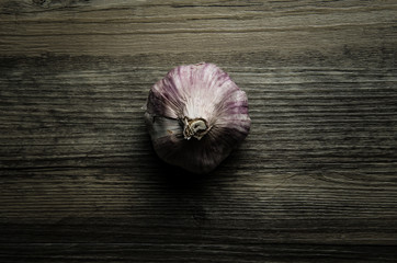 Single rustic garlic on wood 