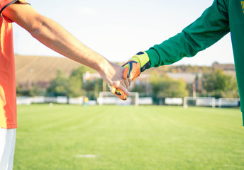 Two soccer players shaking hands in sign of sportsmanship