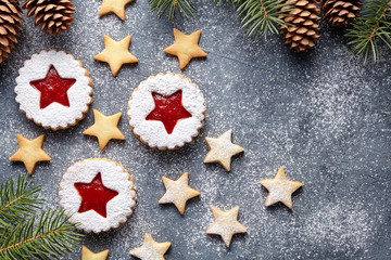 Obraz na płótnie Canvas Christmas or New Year homemade ginger cookies star with strawberry jam. Traditional Austrian dessert - Linzer biscuits. Flat lay. Festive decoration. Top view. Copy space.