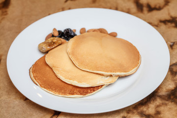 Pancakes on plate with almonds and prunes