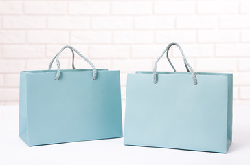 Paper shopping bags on white table close up mock up template for design and text.