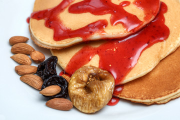 Delicious pancakes with red sweet strawberry syrup