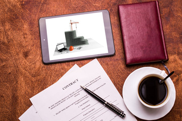 Pen, notebook, tablet, coffee cup, business papers on a wooden table