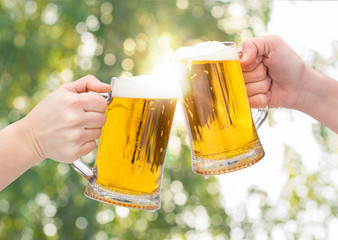 Clinking Beer glasses on blurred background.