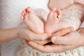 Obraz na płótnie Canvas Baby feet in parents hands. Tiny Newborn Baby's feet on parents