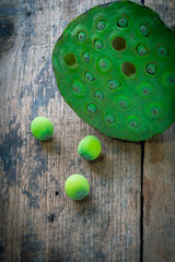 Three lotus seeds and calyx on wooden background