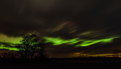 Fototapeta na wymiar Northern lights (Aurora borealis) in the illuminated sky