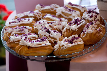 Eclairs, decorated with jam on transparent plate