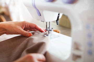 Woman tailor working on sewing machine. Hands. close up.  Tailor