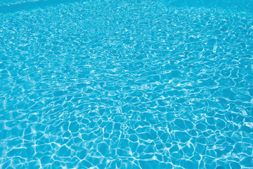 Beautiful blue water surface with sun reflection in swimming pool